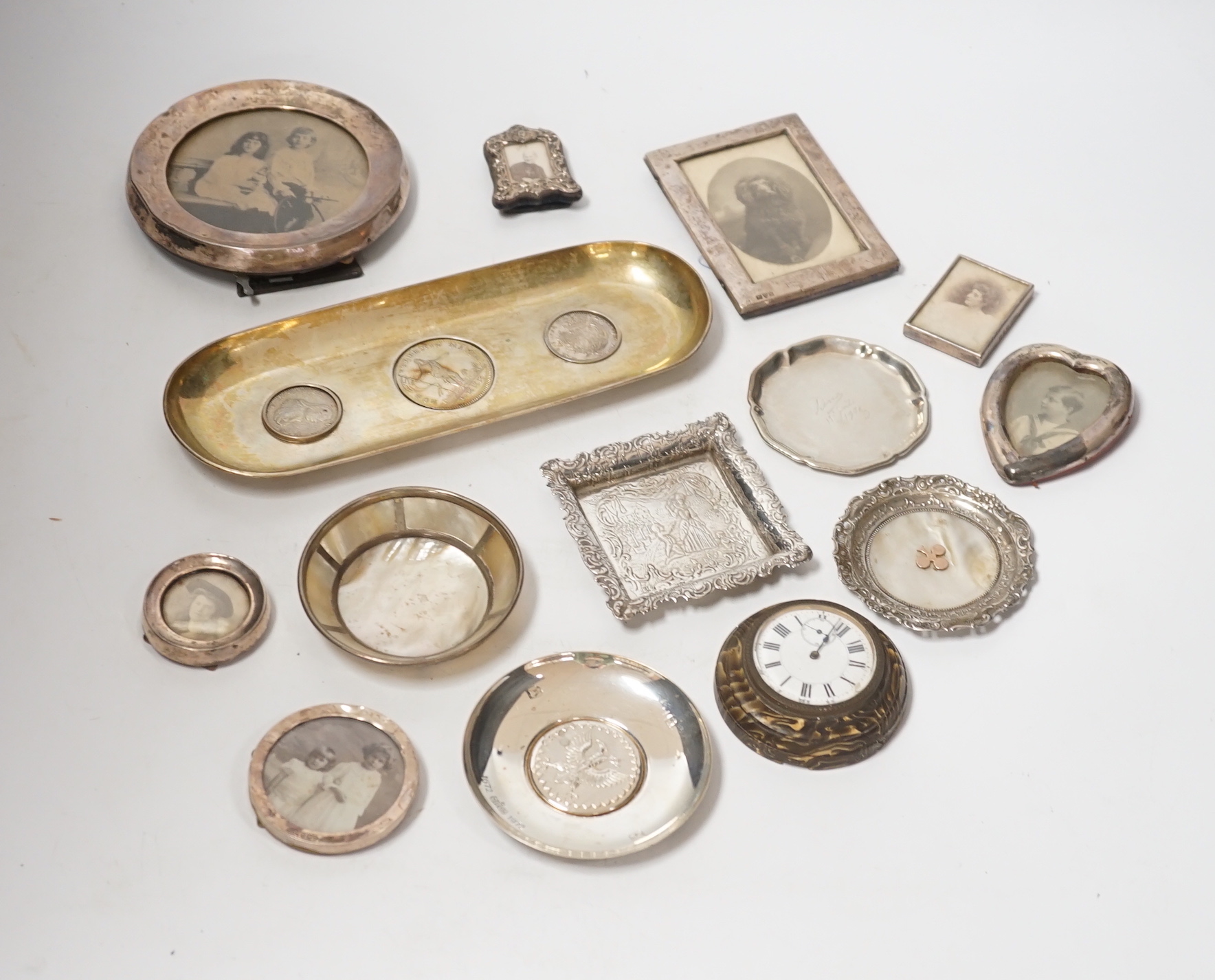 Sundry small silver and white metal items including seven photograph frames, largest 12.5cm, an 800 standard oval dish, inset with three coins, five small dishes and a timepiece.